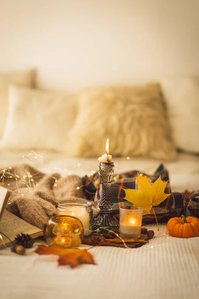 Camisolas e velas com decoração de outono e livro. Leia, Descanse. Ainda detalhes da vida em casa interior. — Fotografia de Stock