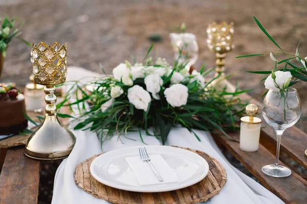 Luxury decorated table for a romantic date. Festive details tablecloth, candles, plates, glasses