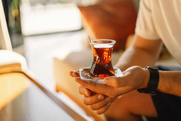 A man drinks Turkish traditional hot tea in the lobby of a Turkish hotel. Turkish tea