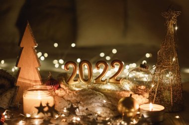Mutlu yıllar 2022. 2022 numara, mumlar tarafından karanlıkta ışıl ışıl parıldayan bir arka planda yapıldı.