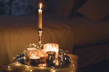 Arka planında şamdan olan bir sürü mum. Ev ve ev dekorasyonu.