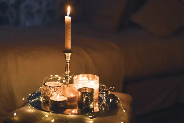 Un sacco di candele con candelabri sullo sfondo della casa. Casa e arredamento domestico. — Foto Stock