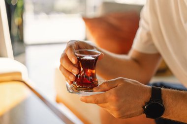 Türk otelinin lobisinde geleneksel Türk çayı içen bir adam. Türk çayı