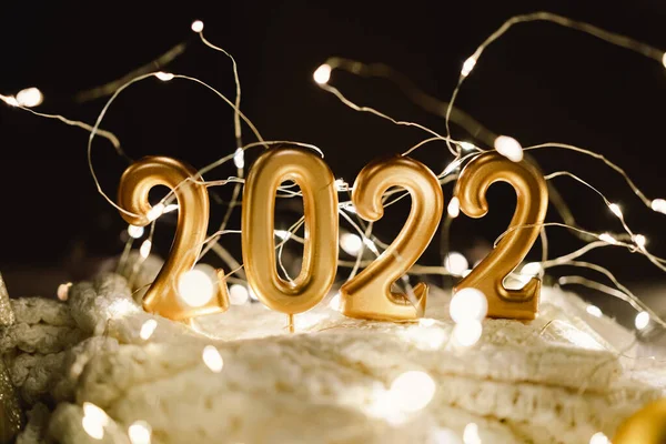 Feliz Año Nuevo 2022. Número 2022 hecho por las velas en un festivo brillante fondo bokeh en la oscuridad — Foto de Stock