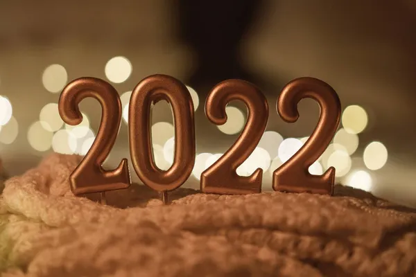 Szczęśliwego Nowego Roku 2022. Liczba 2022 wykonane przez świece na uroczystym, musującym bokeh tle w ciemności — Zdjęcie stockowe