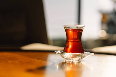 Kırsal masada lale şeklinde camla servis edilen Türk çayı. Geleneksel cam fincanda Türk çayı.