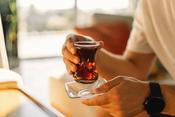 Seorang pria minum teh panas tradisional Turki di lobi hotel Turki. Teh Turki — Stok Foto