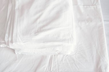 Yatak odasında beyaz rahat yatak ve yumuşak yastık. Beyaz battaniye otel odasında..