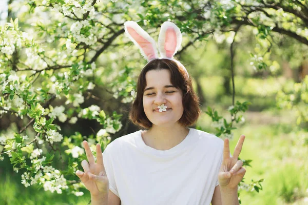 Gadis remaja lucu dengan telinga kelinci pada Paskah berburu telur di taman musim semi cerah — Stok Foto