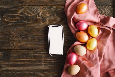 Telefon ve şık renkte paskalya yumurtaları kırsal masada düzleşmişti. Metin için boşluk