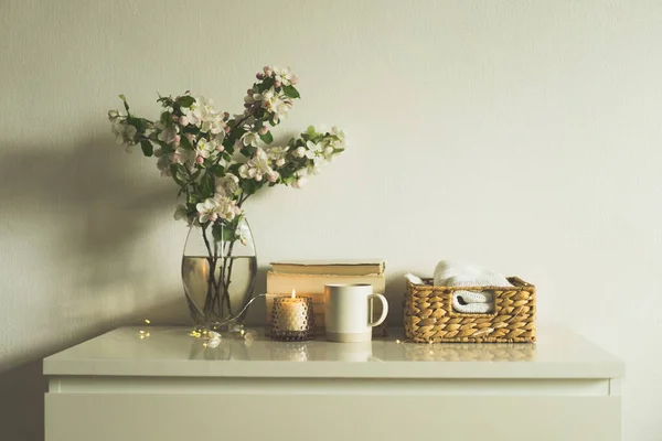 Bok, ljus och vas med äppelvårblommor. — Stockfoto