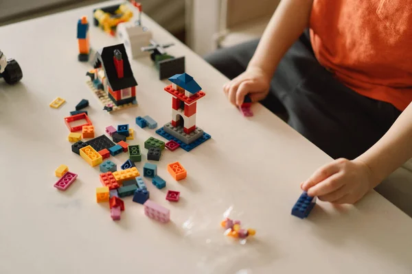 Bonito menino está jogando construtor em casa. Kid brincando de brinquedos de bloco em casa no berçário. — Fotografia de Stock