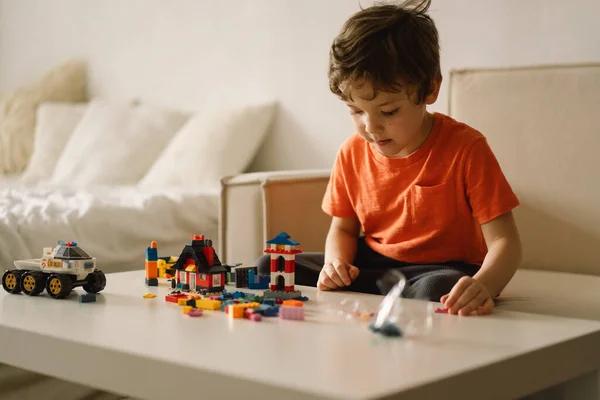 Aranyos fiú építőmunkást játszik otthon. Gyerekjáték otthon a gyerekszobában.. — Stock Fotó
