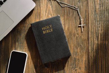Pazar günü kilise online yeni normal konsept. İncil, cep telefonu ve ahşap bir arka planda kulaklık..