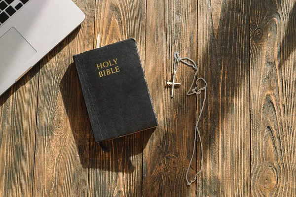 Gereja online Minggu konsep normal baru. Alkitab, telepon genggam, dan penutup telinga dengan latar belakang kayu. — Stok Foto