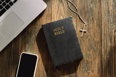 Pazar günü kilise online yeni normal konsept. İncil, cep telefonu ve ahşap bir arka planda kulaklık..