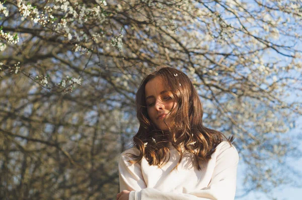 Retrato de una mujer joven y hermosa entre los árboles florecientes. Moda y belleza. Concepto primavera — Foto de Stock