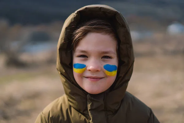 Πορτρέτο ενός Ουκρανού αγοριού με ένα πρόσωπο ζωγραφισμένο με τα χρώματα της ουκρανικής σημαίας. — Φωτογραφία Αρχείου