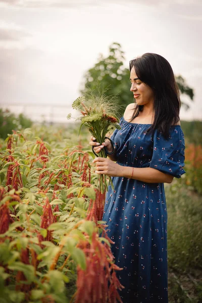 一个年轻的女人在花草繁茂的花圃里修剪花朵.女花匠. — 图库照片