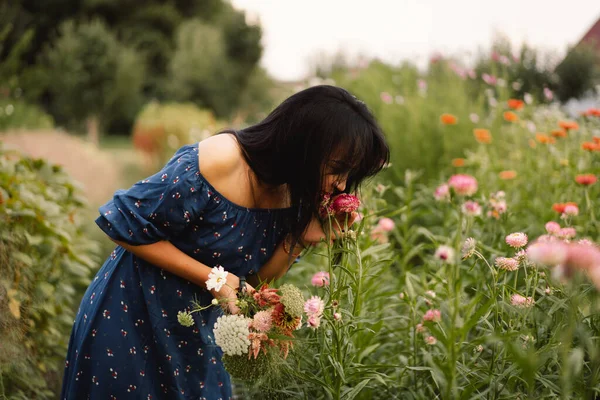 A Young woman prune flowers in a floristic flower farm. Woman florist. — Stock Photo, Image