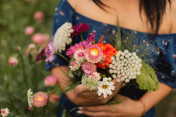 Młoda kobieta spaceruje z bukietem kwiatów w kwiaciarni. — Zdjęcie stockowe