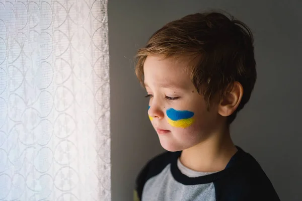 Potret seorang anak laki-laki Ukraina dengan wajah dicat dengan warna bendera Ukraina. — Stok Foto