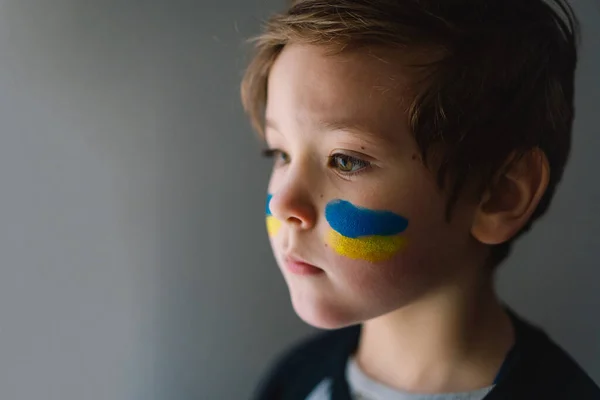 Potret seorang anak laki-laki Ukraina dengan wajah dicat dengan warna bendera Ukraina. — Stok Foto