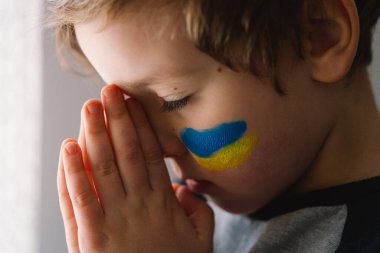 Ukraynalı çocuk gözlerini kapadı ve Ukrayna 'daki savaşı durdurmak için dua etti..