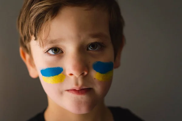 Портрет українського хлопчика з обличчям, намальованим кольорами українського прапора.. — стокове фото