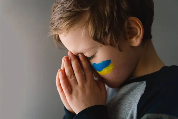 Pemuda Ukraina menutup matanya dan berdoa untuk menghentikan perang di Ukraina.. — Stok Foto