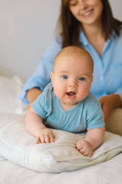 Mutlu bir anne ve çocuğun portresi. Genç bir anne, küçük bir bebekle oynuyor.