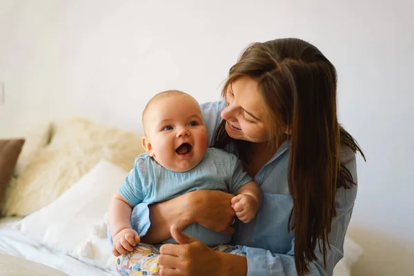 Retrato de una madre y un niño felices. Una madre joven está jugando con un niño pequeño — Foto de Stock