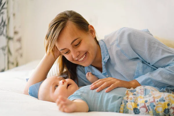 Retrato de una madre y un niño felices. Una madre joven está jugando con un niño pequeño — Foto de Stock