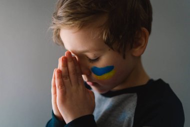 Ukraynalı çocuk gözlerini kapadı ve Ukrayna 'daki savaşı durdurmak için dua etti..