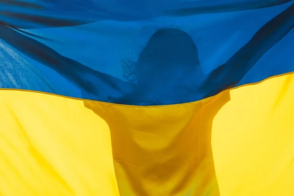 Mulher segurando uma bandeira amarela e azul da Ucrânia ao ar livre — Fotografia de Stock