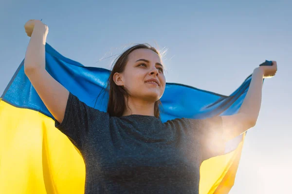 Γυναίκα κρατώντας μια κίτρινη και μπλε σημαία της Ουκρανίας σε εξωτερικούς χώρους — Φωτογραφία Αρχείου