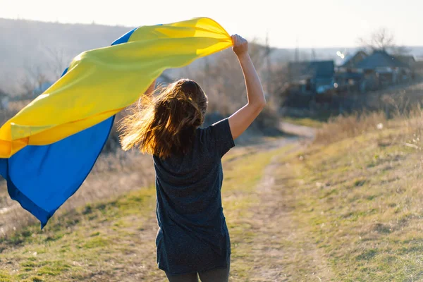 Wanita yang memegang bendera kuning dan biru Ukraina di luar ruangan. — Stok Foto