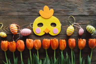 Bahar laleleri ve ahşap arka planda çok renkli Paskalya yumurtaları..