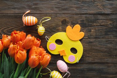 Bahar laleleri ve ahşap arka planda çok renkli Paskalya yumurtaları..