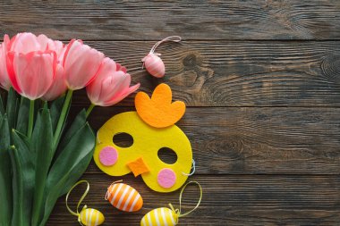 Bahar laleleri ve ahşap arka planda çok renkli Paskalya yumurtaları..