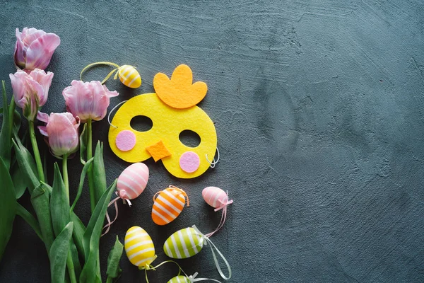 Bahar laleleri ve ahşap arka planda çok renkli Paskalya yumurtaları..