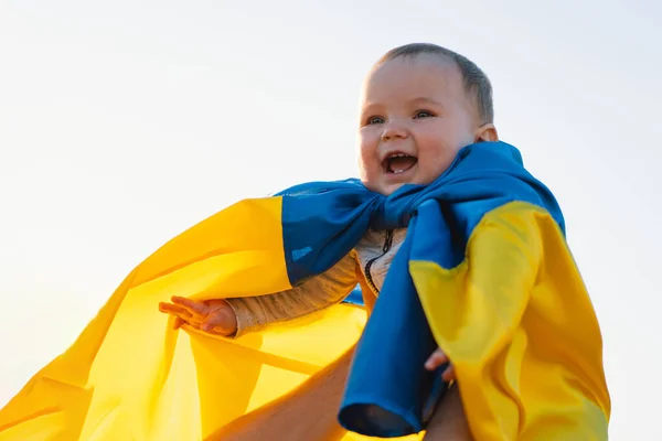 Anak kecil yang dibungkus dengan bendera kuning dan biru Ukraina di luar ruangan. Hari Kemerdekaan. — Stok Foto