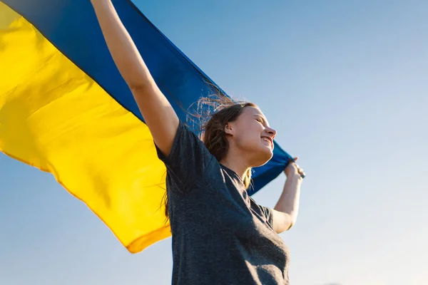 Mujer sosteniendo una bandera amarilla y azul de Ucrania al aire libre — Foto de Stock