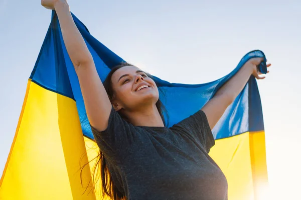 Женщина с желто-голубым флагом Украины на открытом воздухе — стоковое фото