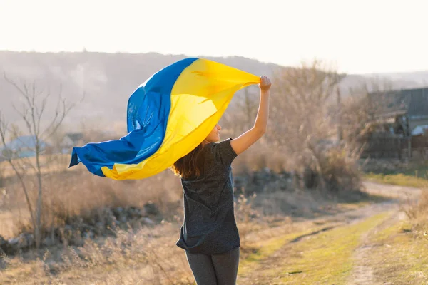 Wanita yang memegang bendera kuning dan biru Ukraina di luar ruangan. — Stok Foto