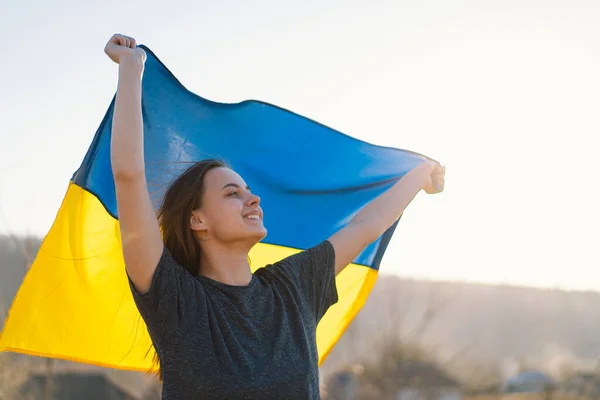 Γυναίκα κρατώντας μια κίτρινη και μπλε σημαία της Ουκρανίας σε εξωτερικούς χώρους — Φωτογραφία Αρχείου