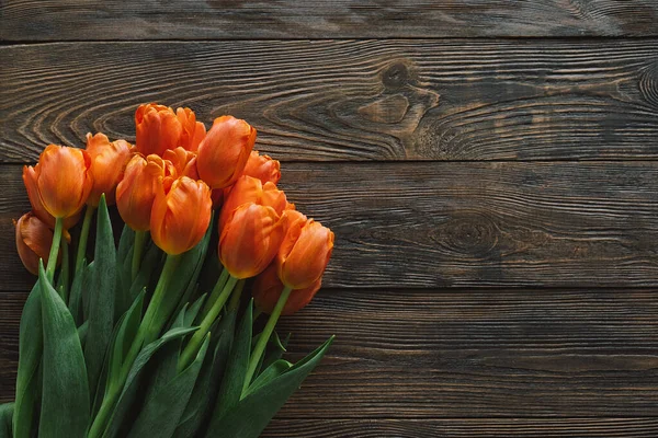 Tulipanes frescos sobre fondo de madera. Tarjeta de felicitación con estilo — Foto de Stock