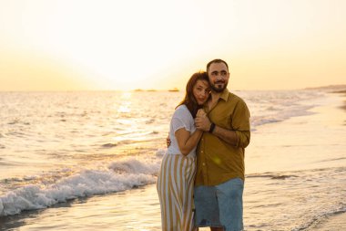 Genç romantik çift denizde dans ediyor. Gün batımında deniz manzarası Güzel gökyüzü