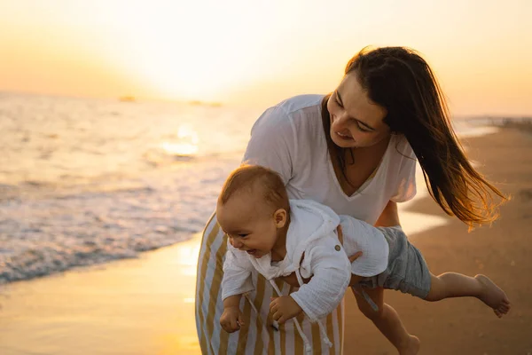 Happy mothers day. Beautiful mother and baby play on the beach. — Stock fotografie