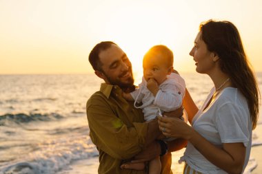 Mutlu bir aile, yaz tatilinde sahilde plaj oynarken eğleniyor..